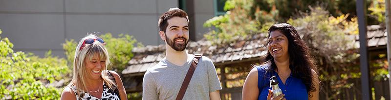 Photo of three managment students outside on campus